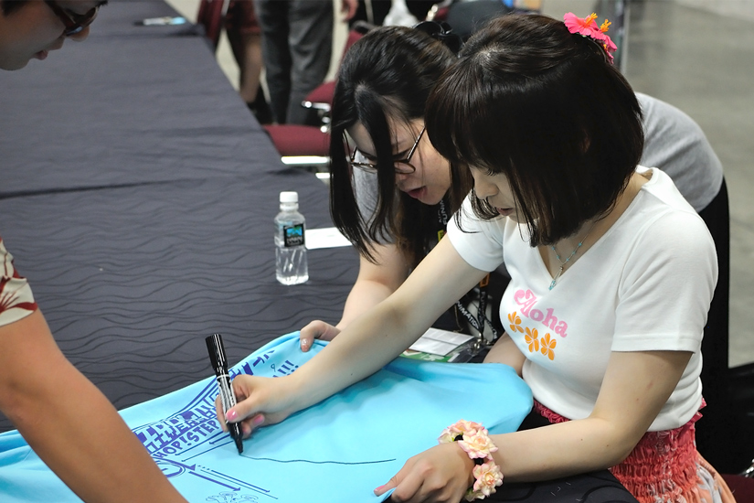 Shimoda signs an Idolmaster concert T-shirt