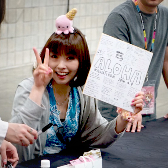 Shimoda poses with shikishi given to her by fans